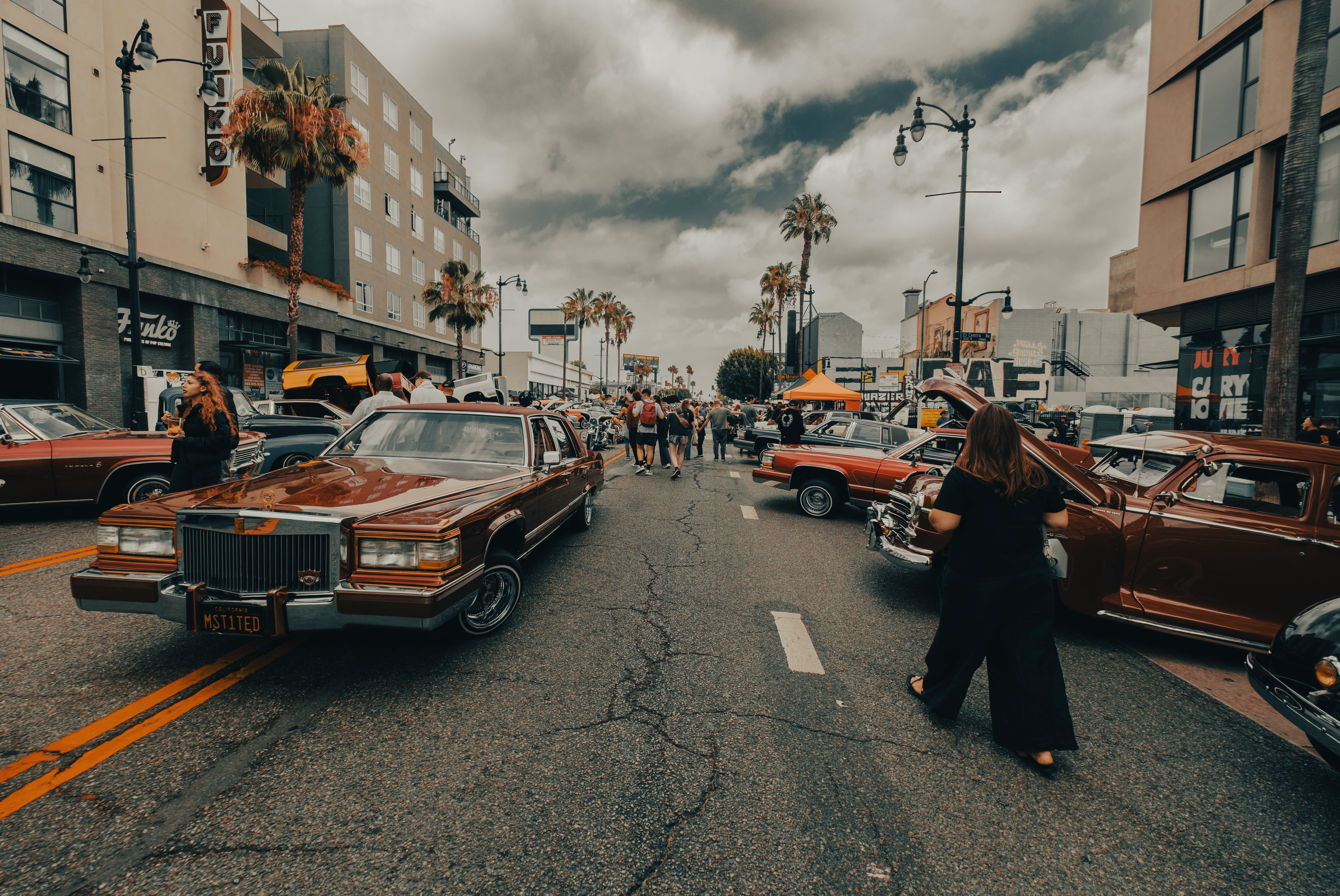 A photographer capturing classic cars at an outdoor car show.
