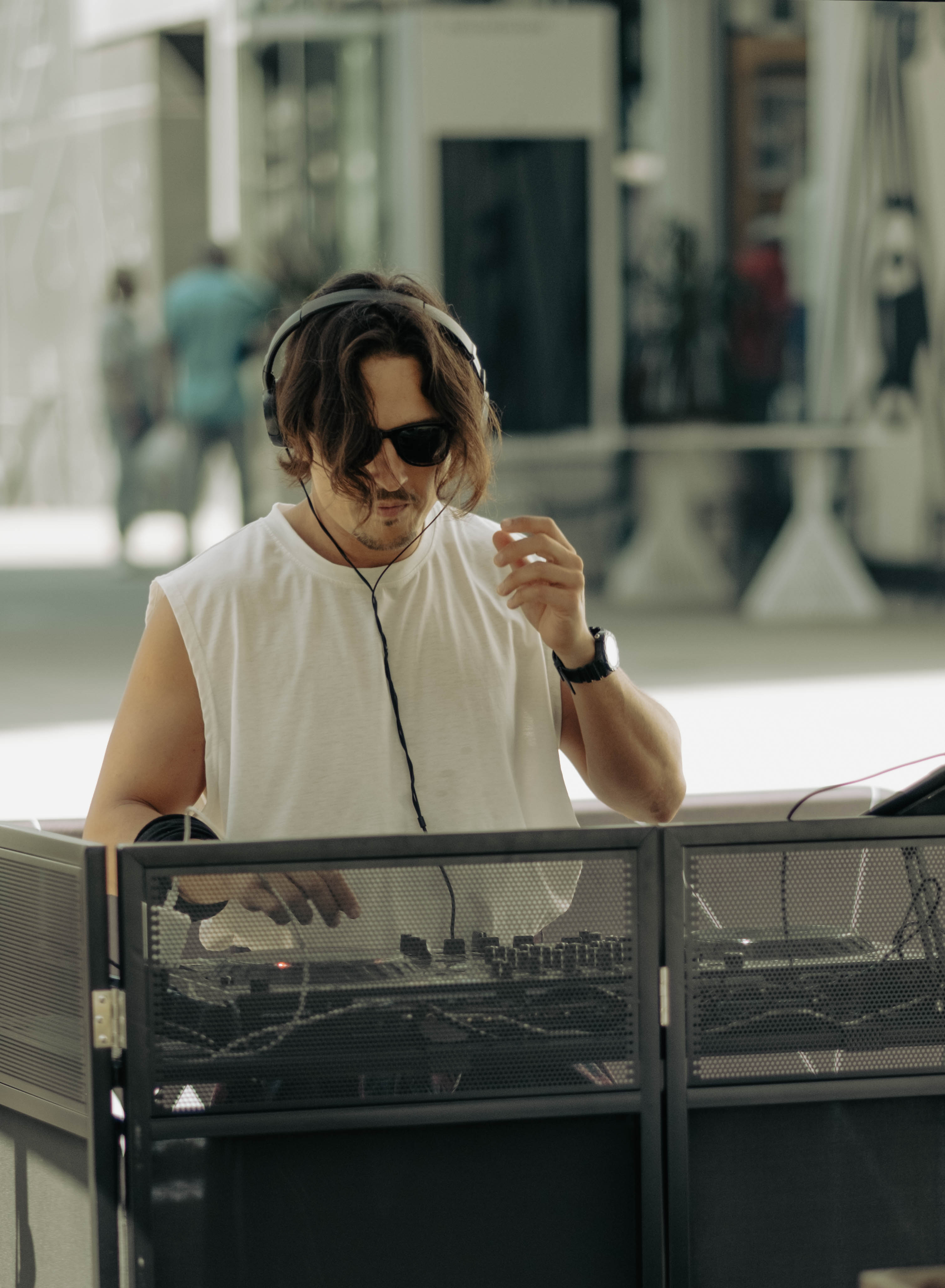 DJ Vento wearing headphones while performing at an outdoor event.